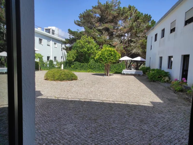 The cobblestone courtyard between the venue buildings, with shaded outdoor seating